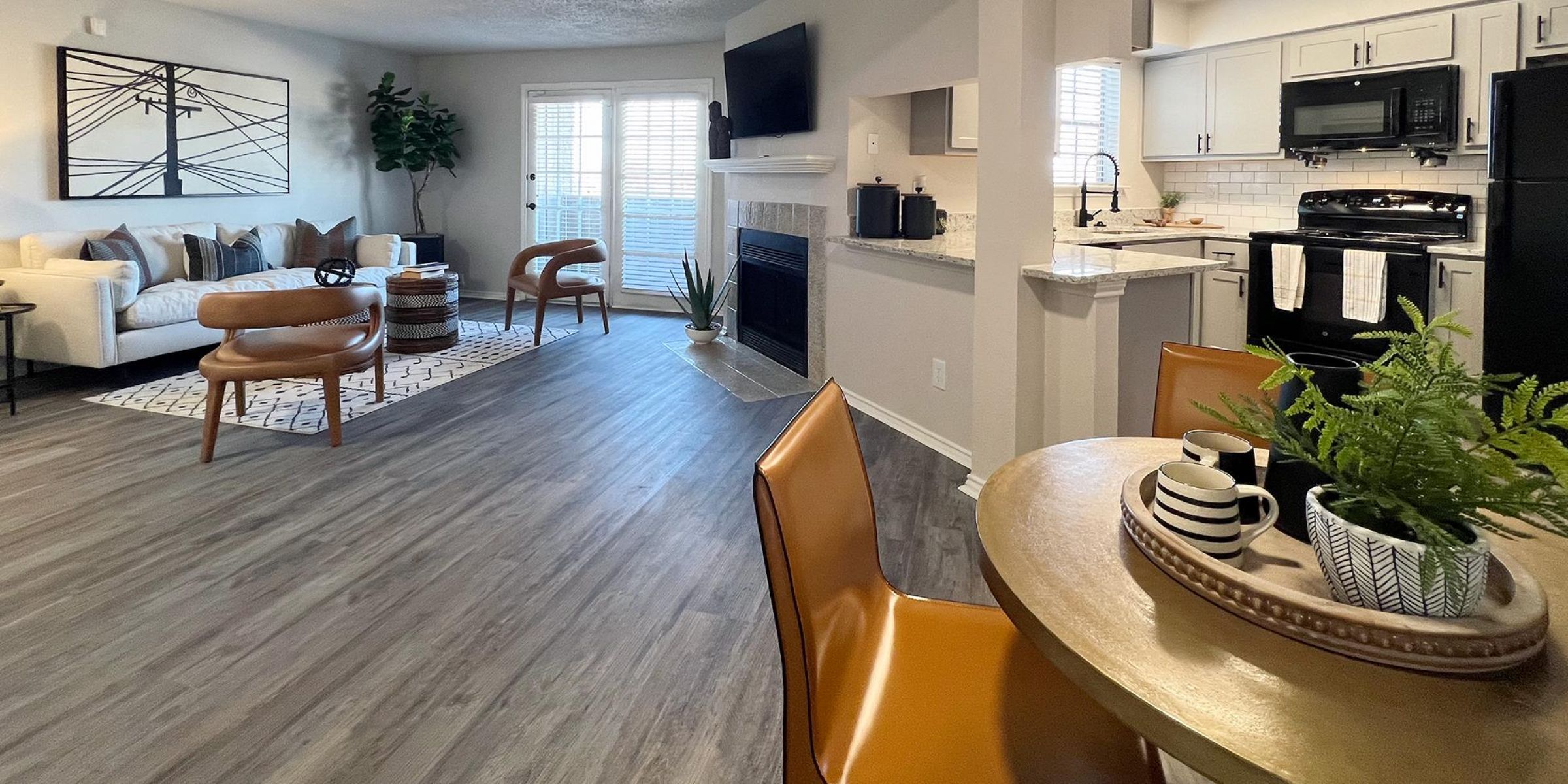 Luxury apartment living room with large windows, wood style floors and contemporary furniture at The Civic at Frisco Square